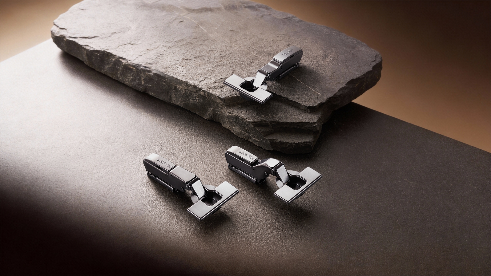 FELINE soft-closing cabinet hinges displayed on stone