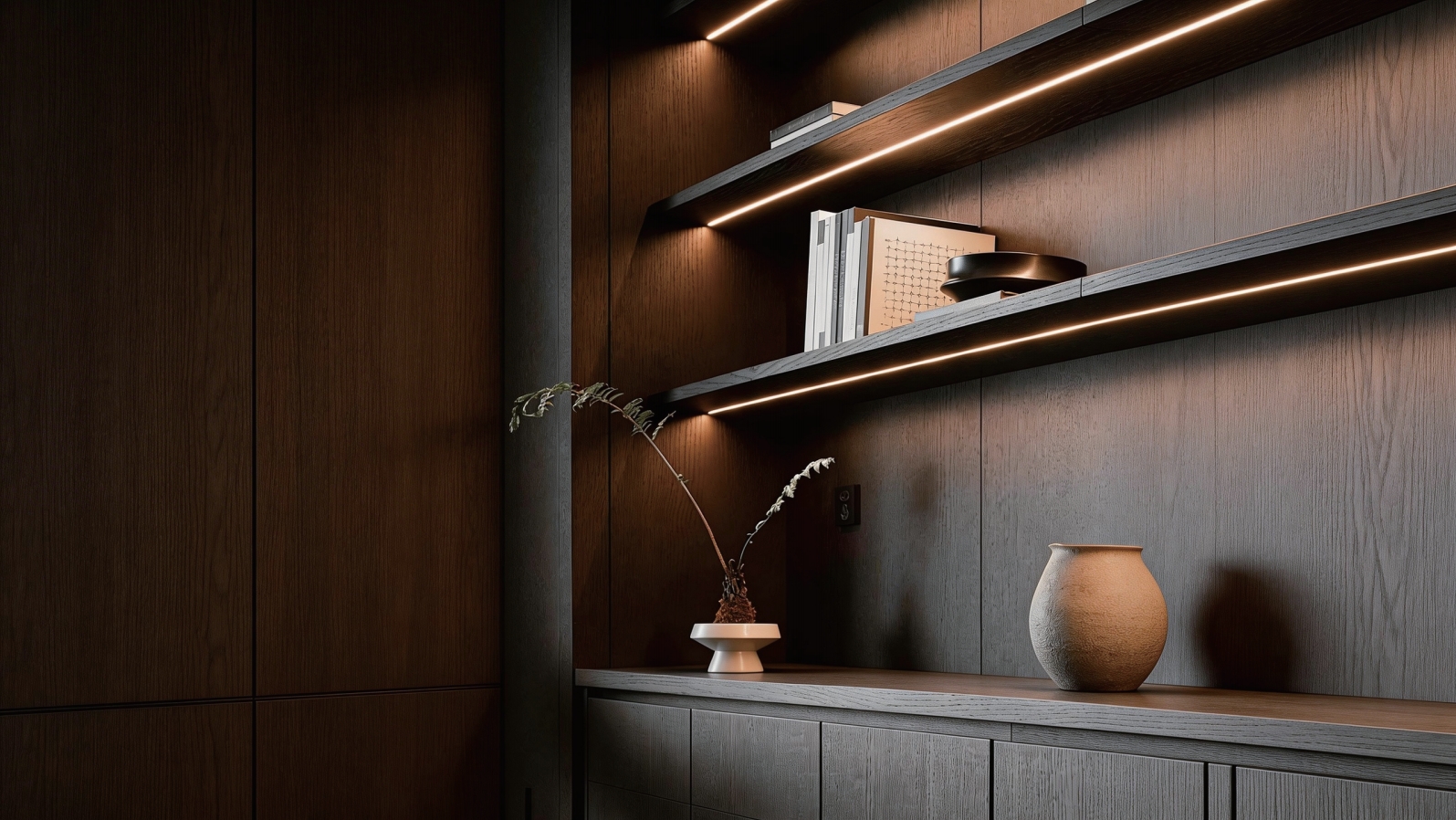 Warm LED cabinet lighting under floating shelves in a dark wood interior